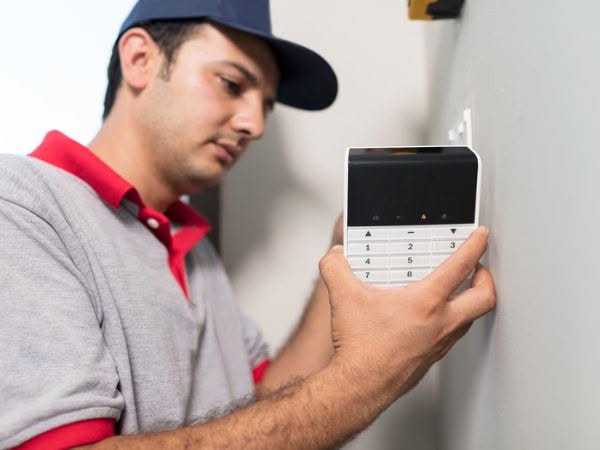 Operaio installa allarme in un condominio
