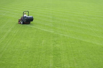 manutenzione di un campo da calcio con taglio erba